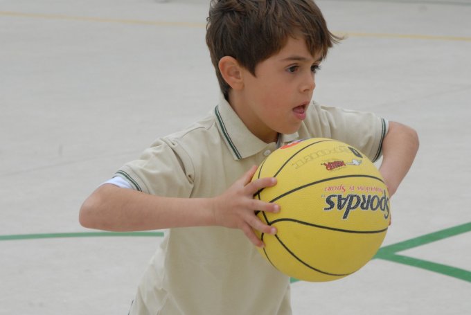 Chłopiec rozwija się poprzez aktywność fizyczną podczas gry w koszykówkę