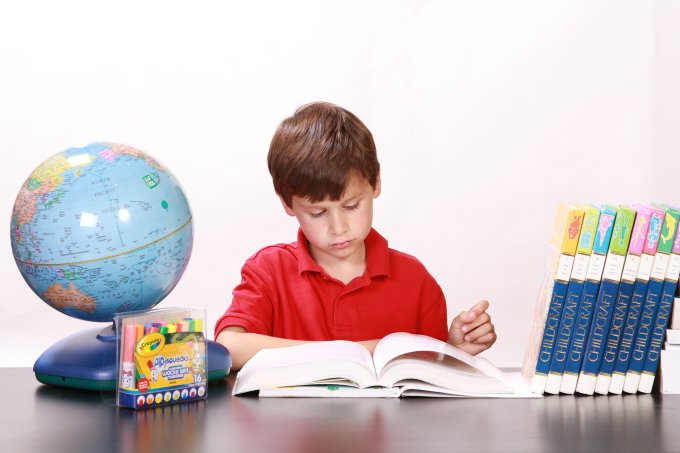 Chłopiec uczy się przy biurku rozwijając swoje zdolności intelektualne
