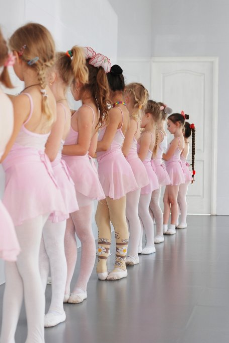 Dziewczynki w różowych sukienkach podczas lekcji baletu
